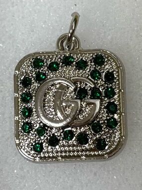 Gucci silver tone charm with emerald-green stones